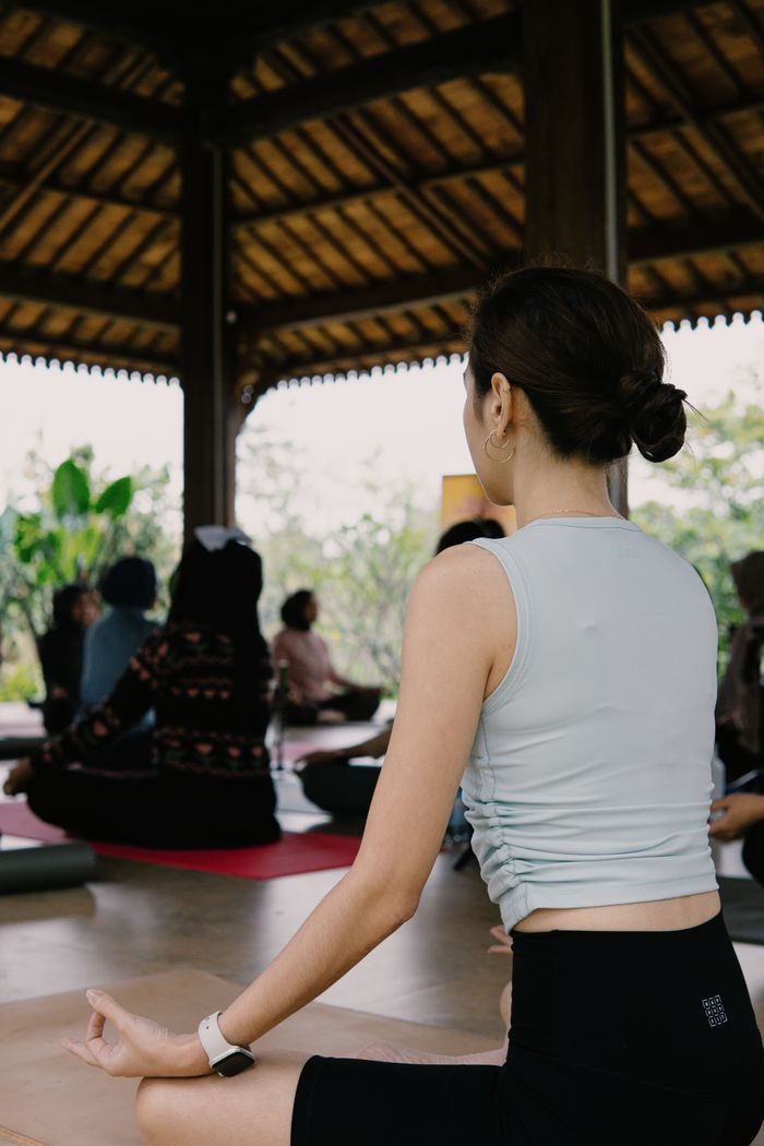Group practicing yoga in a serene Indonesian pavilion, offering relaxation and mindfulness.